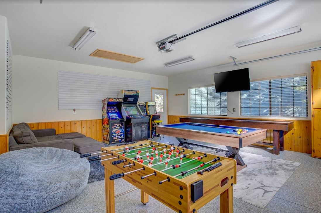 Game room with pool table, foosball, arcade games, and shuffleboard