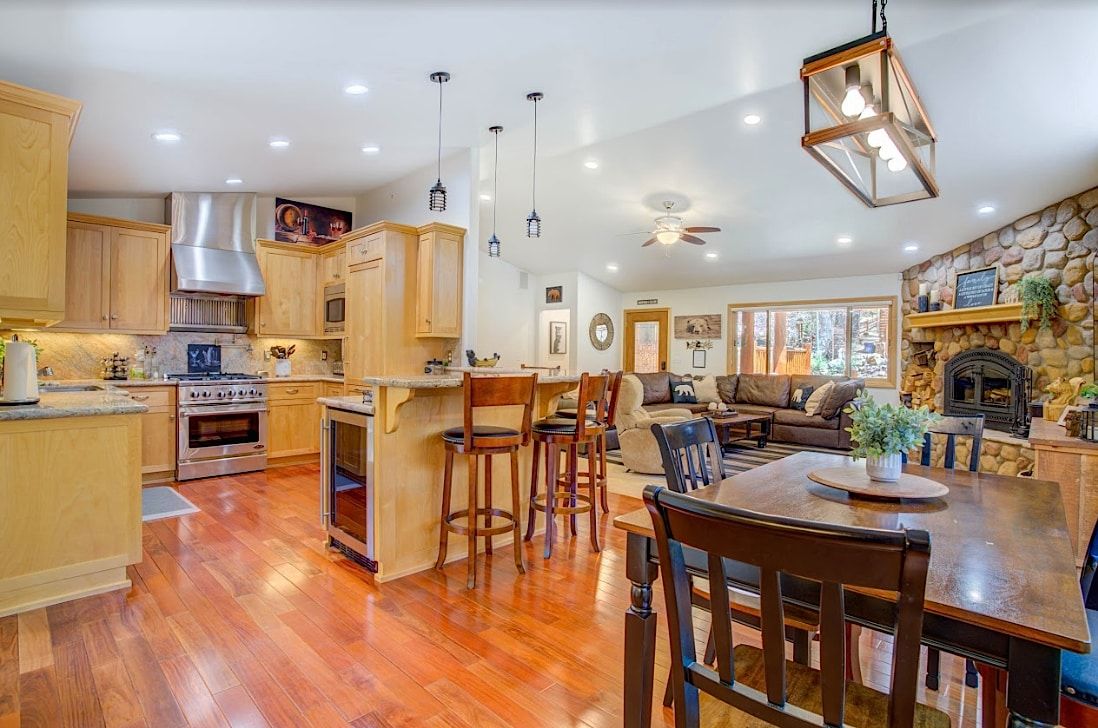 Gourmet kitchen with maple cabinets, stainless steel range, breakfast bar, and dining table