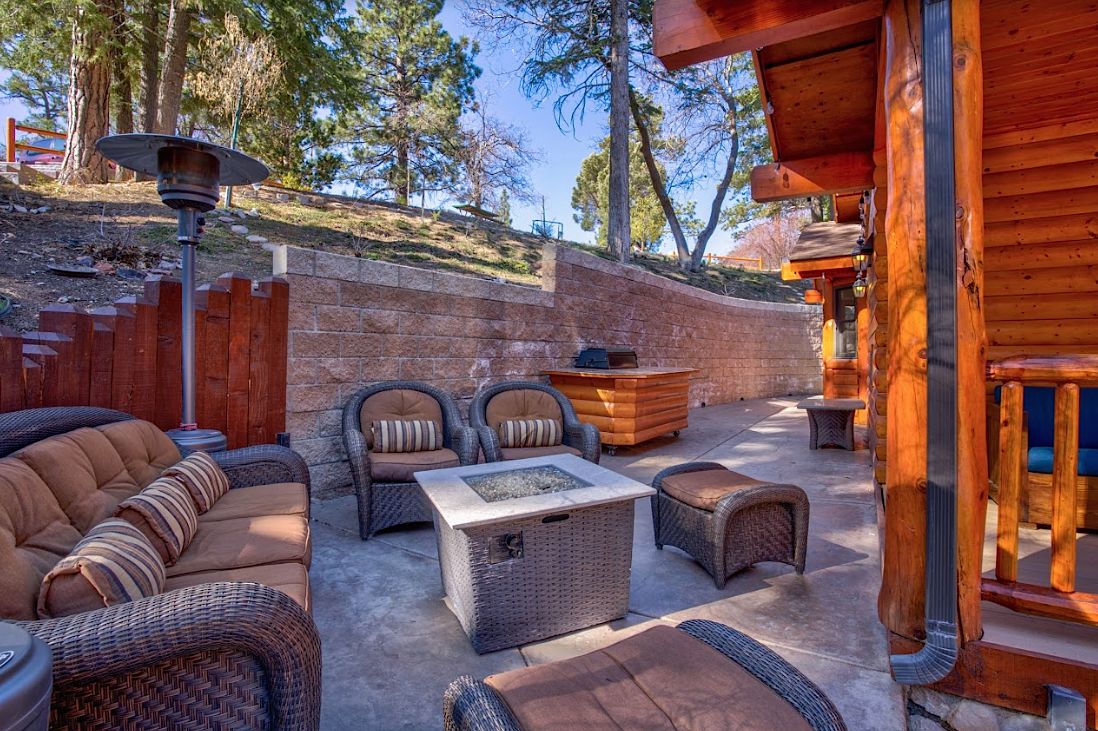 Side patio with wicker seating, fire pit table, patio heater, and BBQ grill