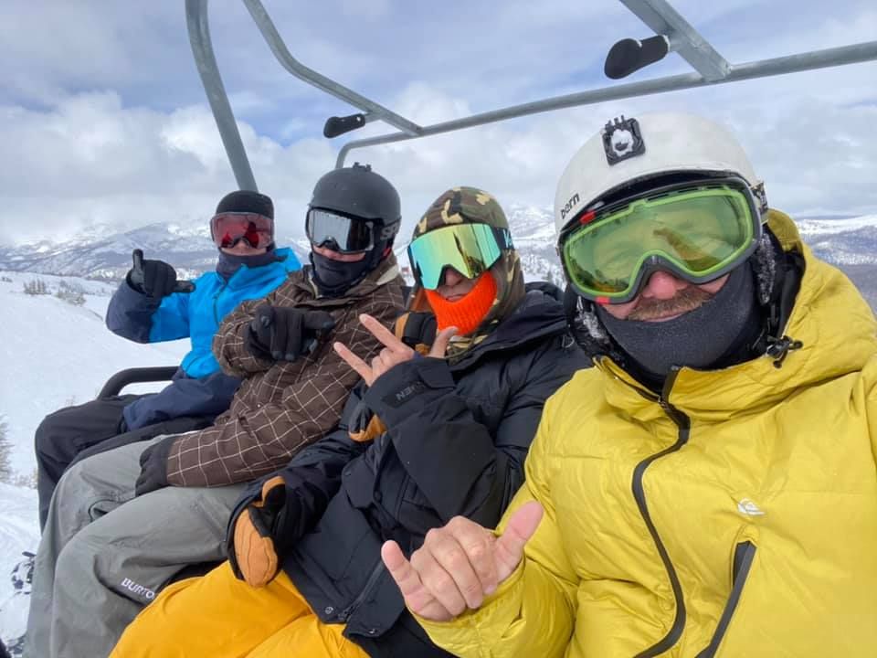 Skiers riding the chairlift with snowy mountain views