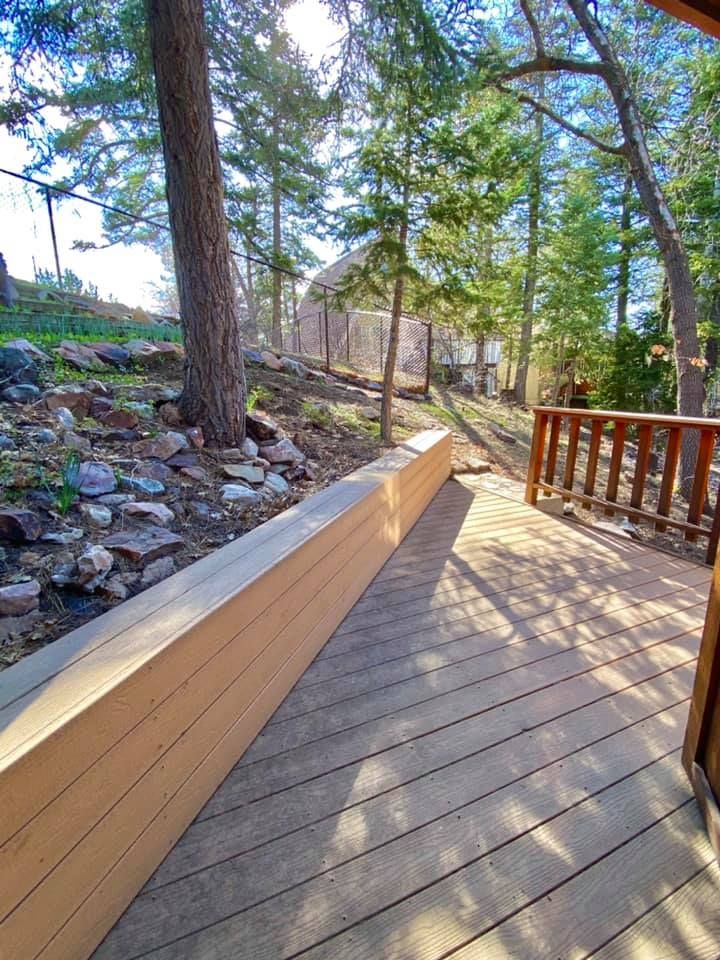 Wooden deck walkway winding through the pine trees beside the cabin